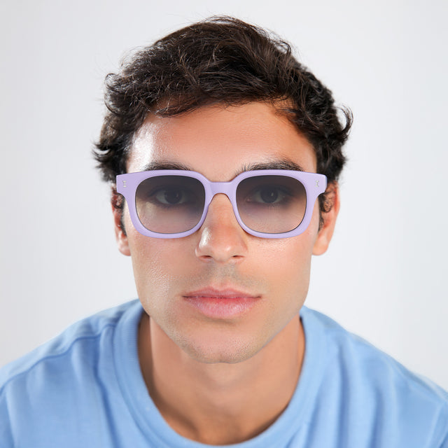 Man with brown hair in a baby blue shirt wearing Ellison Sunglasses Matte Lavender with Olive Flat Gradient