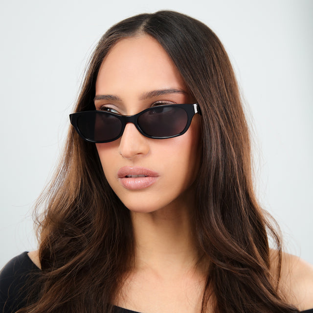 Woman with brown hair in a black off the shoulder blouse wearing Encinitas Sunglasses Black with Grey