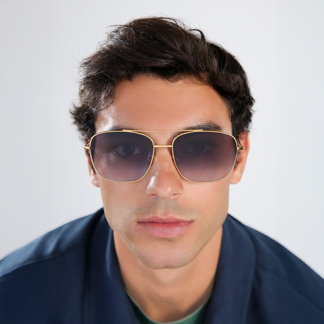 Another angle of man with brown hair in a navy blue jacket wearing Frankie Sunglasses Gold with Grey Flat Gradient