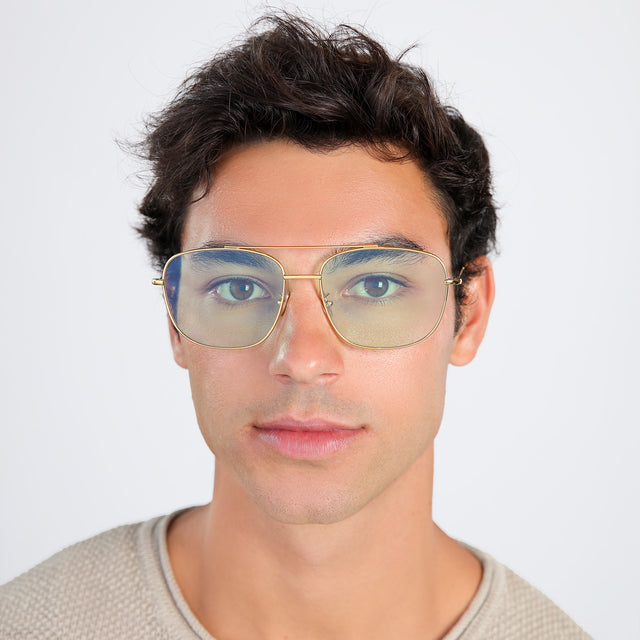 Another angle of man with brown hair in a beige waffled sweatshirt wearing Frankie Sunglasses Gold with Mint Flat See Through
