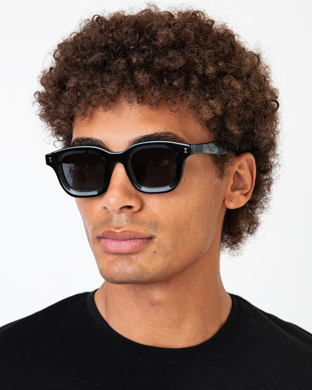 Model with afro-curly hair wearing George Sunglasses Black with Grey Flat