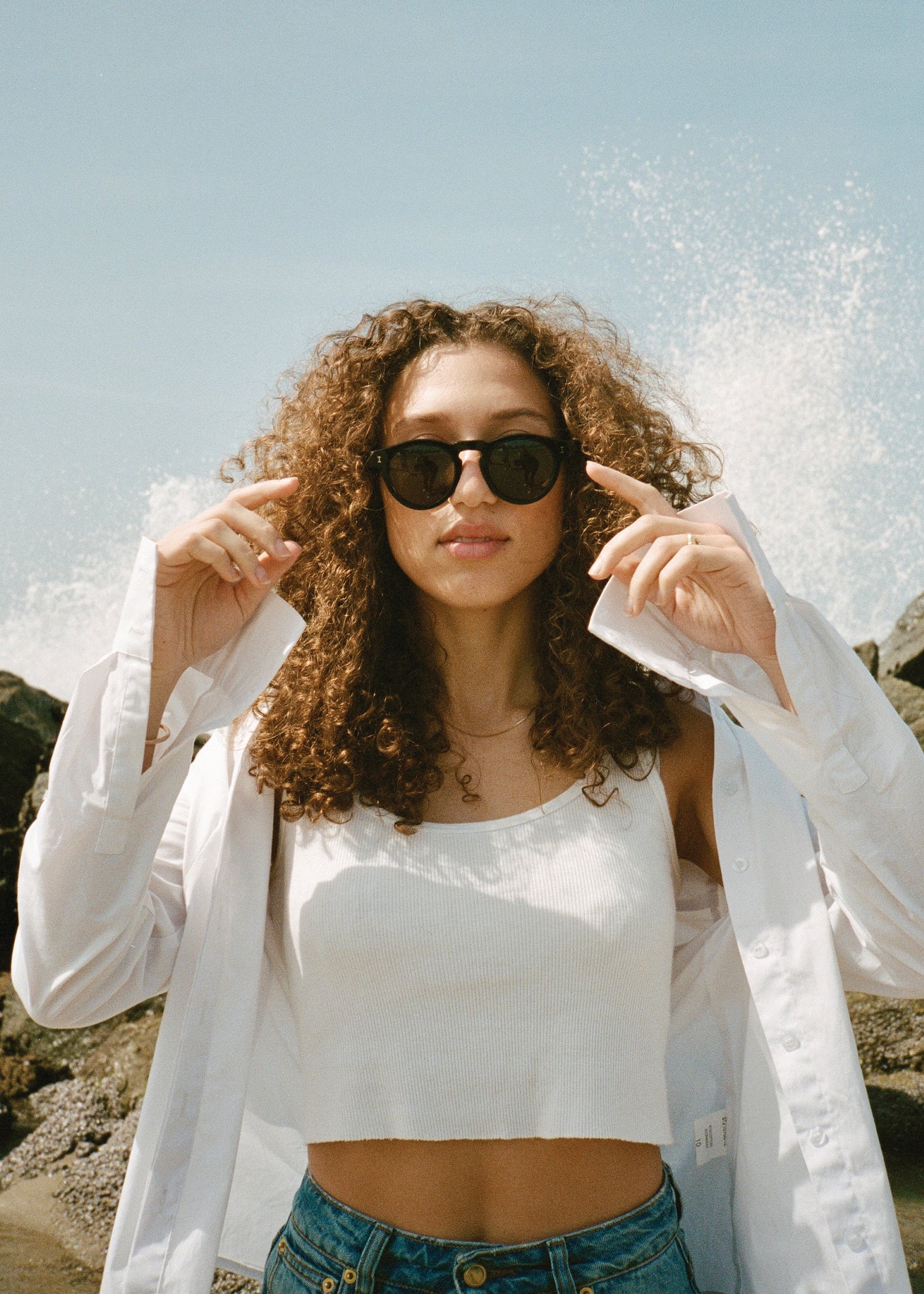 Woman at the beach wearing Gray Malin x illesteva