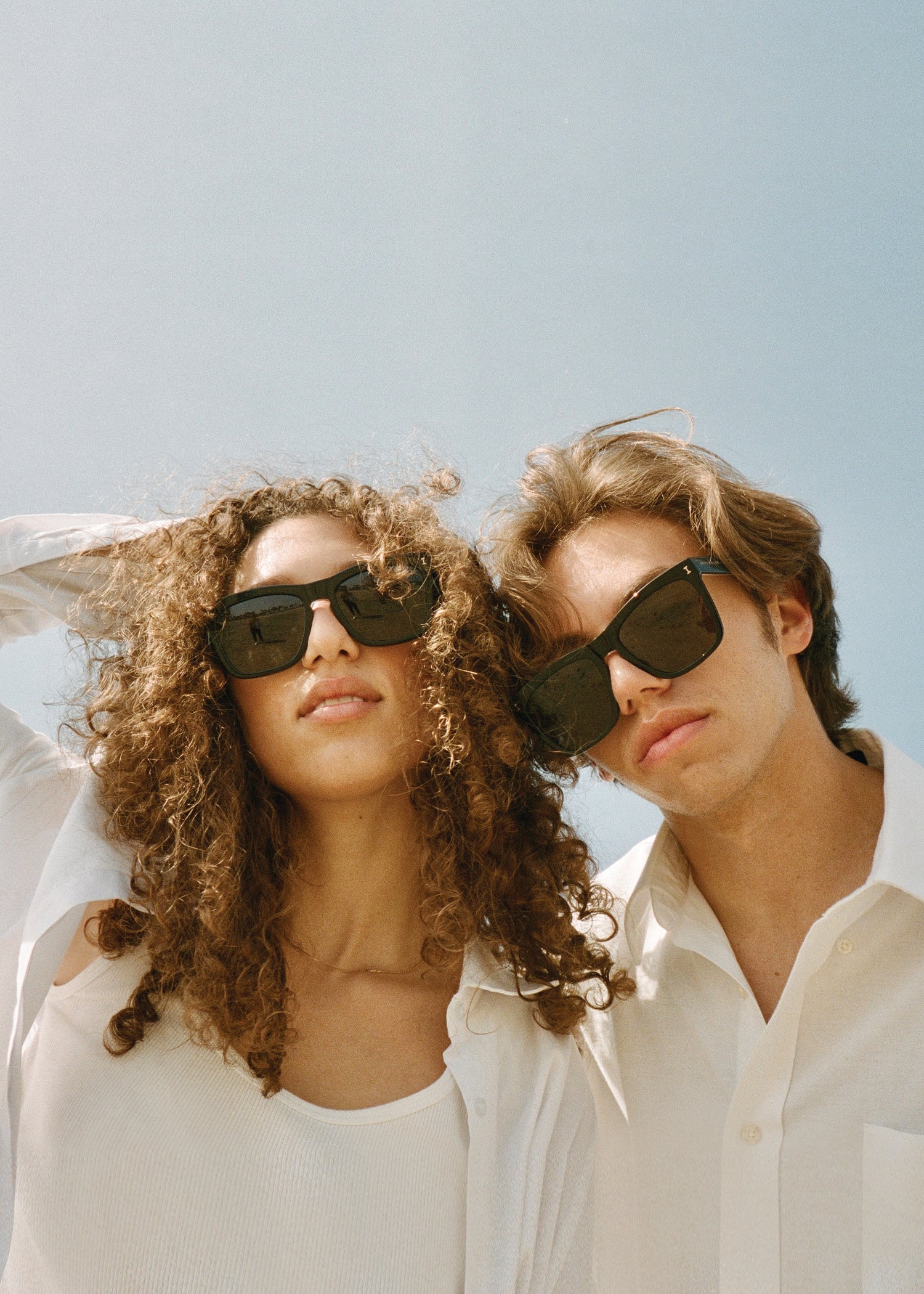 Man and woman at the beach wearing Gray Malin x illesteva