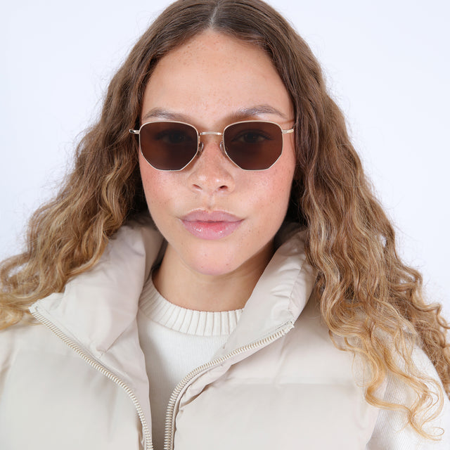 Brunette with ombre, natural curls wearing Hunter Sunglasses Gold with Brown