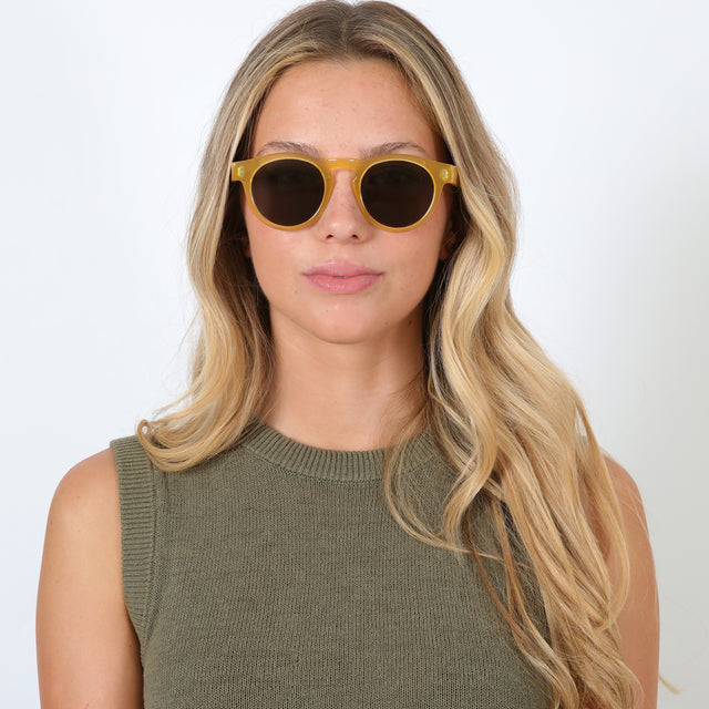 Blonde model with loose curls wearing Leonard Sunglasses Blond with Grey