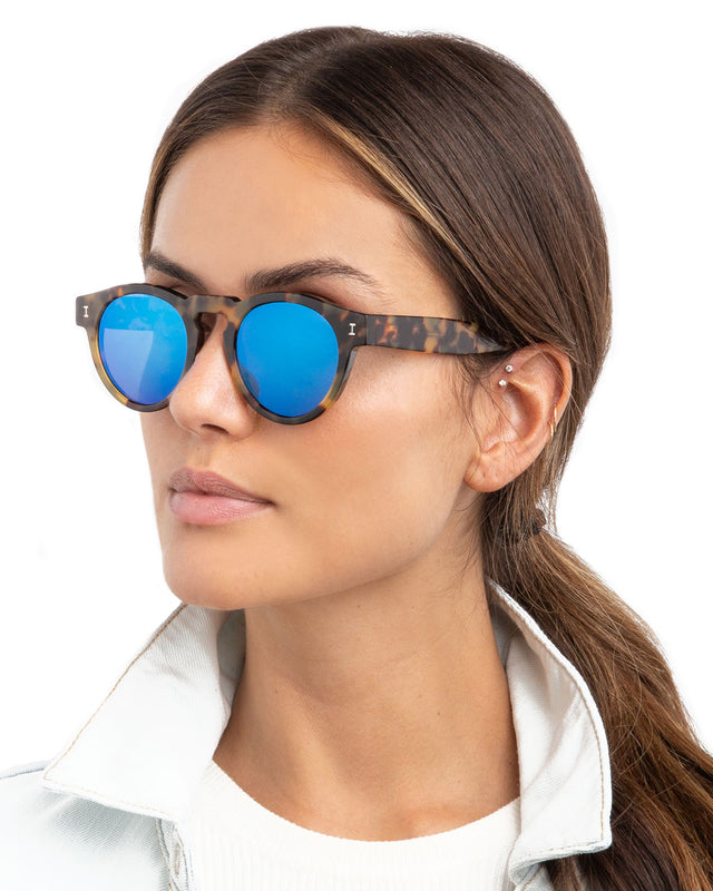 Brunette with a low ponytail wearing Leonard Sunglasses Tortoise with Blue Mirror