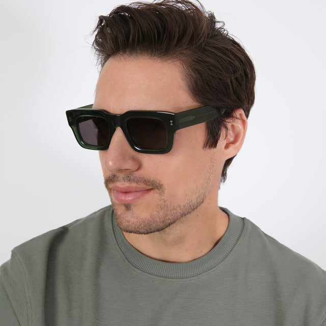 Model with short brown hair in an olive shirt wearing Lewis 50 Sunglasses Pine with Grey Flat