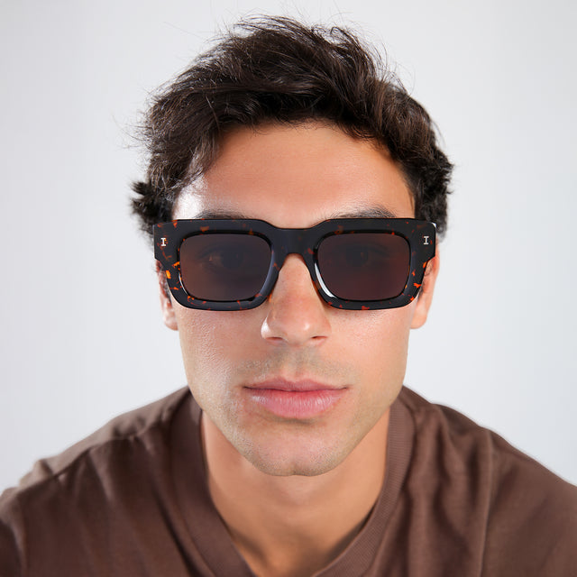 Another angle of man with brown hair in a brown shirt wearing Lewis 50 Sunglasses Flame with Brown Flat