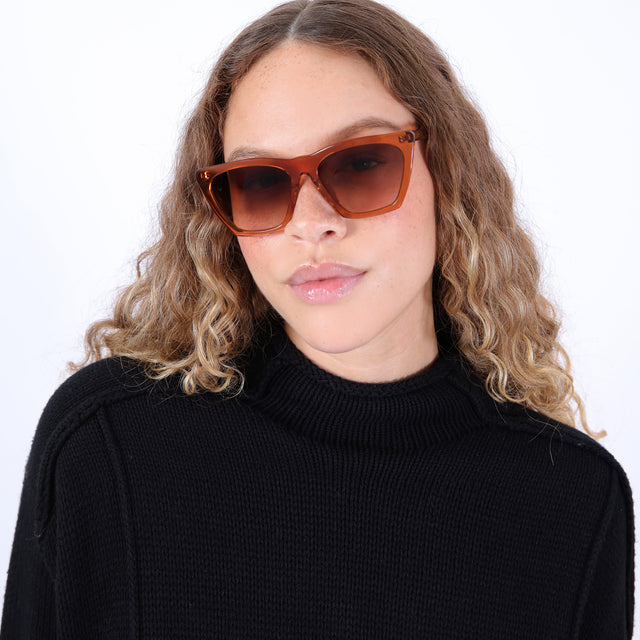 Brunette model with ombre, natural curls wearing Lisbon 57 Sunglasses Cider with Brown Gradient