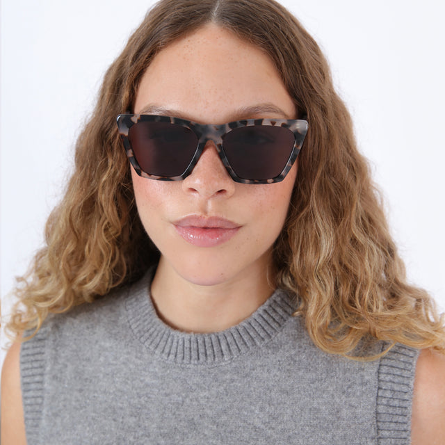 Brunette model with ombre wavy hair wearing Lisbon Sunglasses White Tortoise with Grey