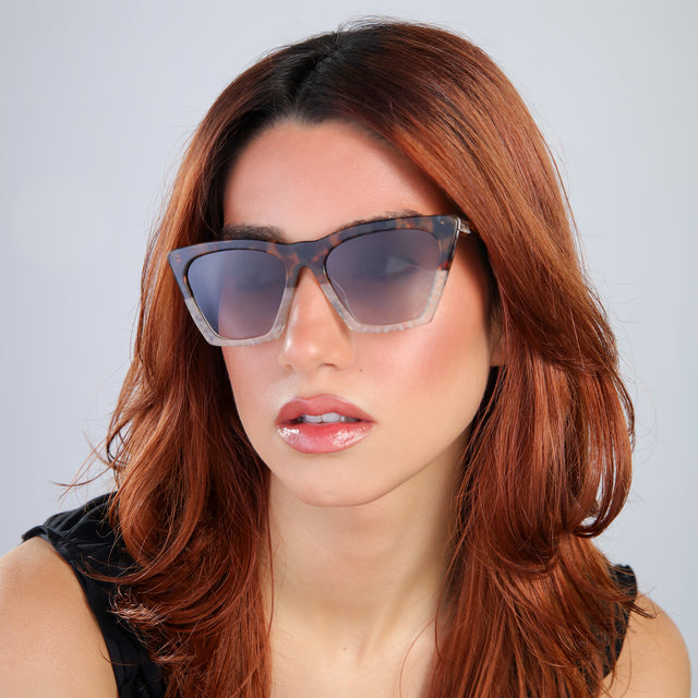 Another angle of woman with red hair in a black blouse Lisbon Sunglasses side view in H/H Maple Bone / Grey Gradient