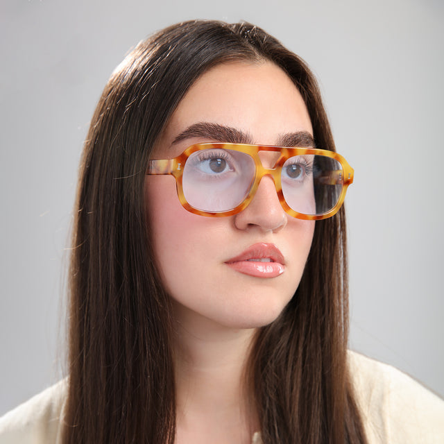 Woman with straight brown hair wearing Memphis Sunglasses Amber with Light Blue See Through