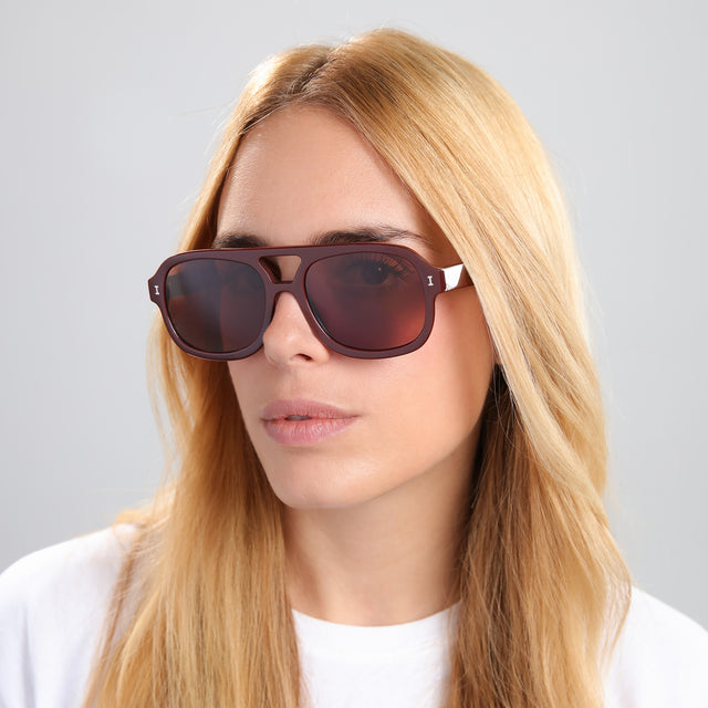 Blonde woman in a white blouse wearing Memphis Sunglasses Bordeaux with Brown