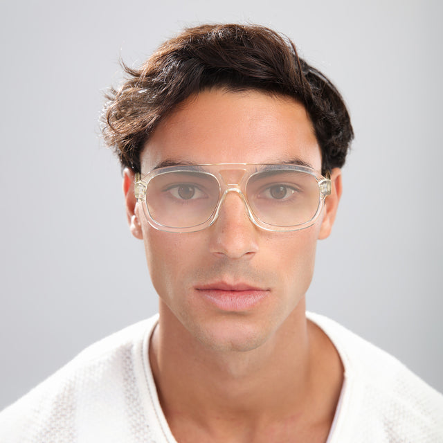 Man in a textured white shirt wearing Memphis Sunglasses Champagne with Taupe Gradient