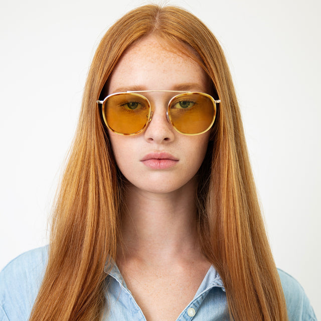 Model with straight red hair wearing Mykonos Ace Sunglasses Amber/Gold with Honey Flat See Through