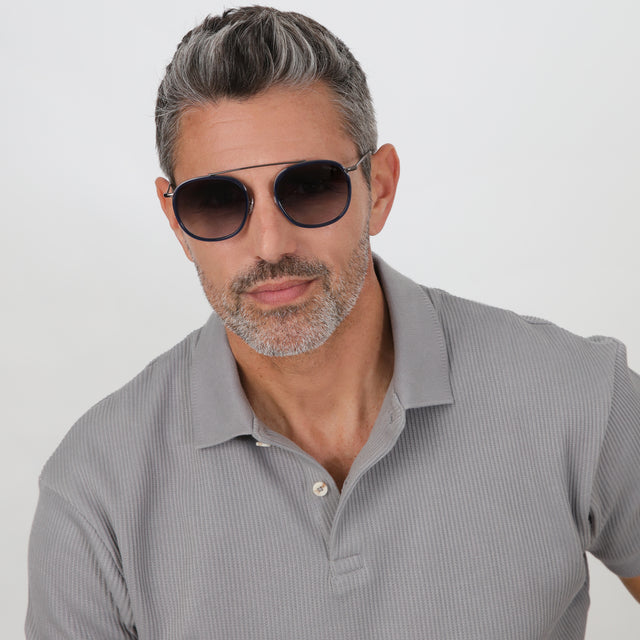 Model with salt and pepper hair and beard wearing Mykonos Ace Sunglasses Navy/Gunmetal with Grey Flat Gradient