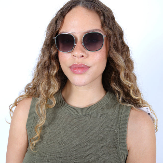 Brunette model with ombré, curled hair wearing Mykonos Ace Sunglasses Pine/Silver with Grey Flat Gradient