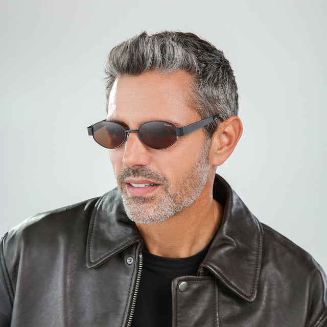Bearded model looking right wearing Nesso Sunglasses Matte Black with Brown