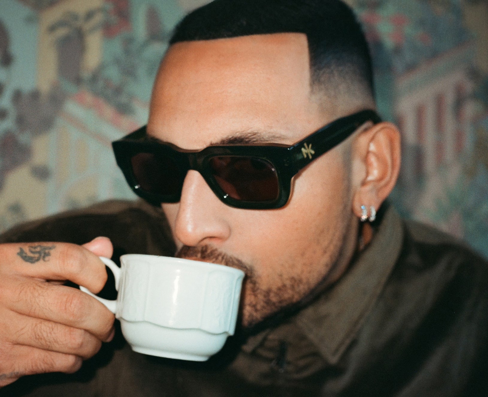 Nick Kyrgios at a barista bar sipping an espresso wearing Nick Kyrgios x illesteva Sunglasses in Black with Grey