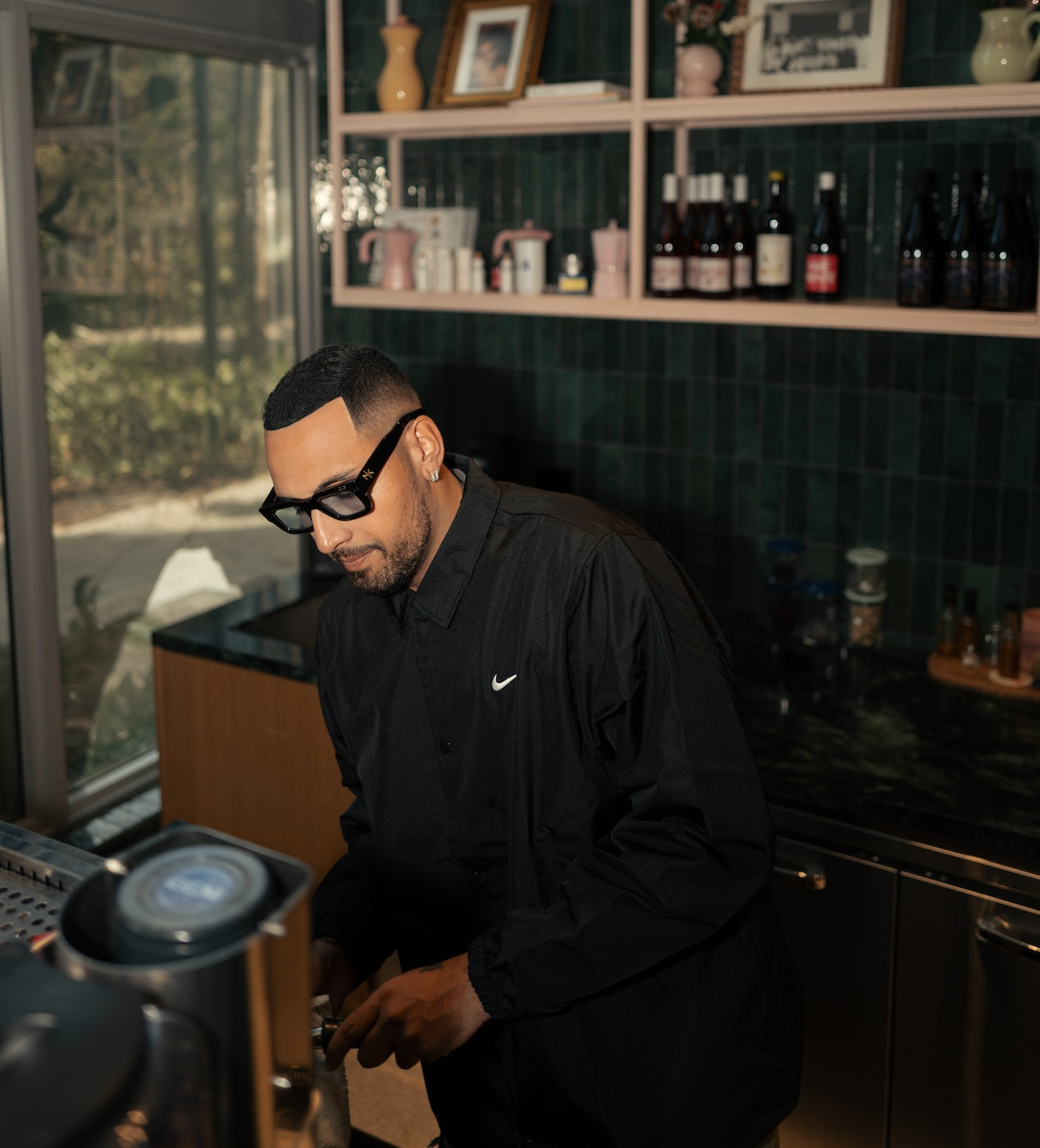 Nick Kyrgios at a barista bar wearing Nick Kyrgios x illesteva Sunglasses in Black with Blue