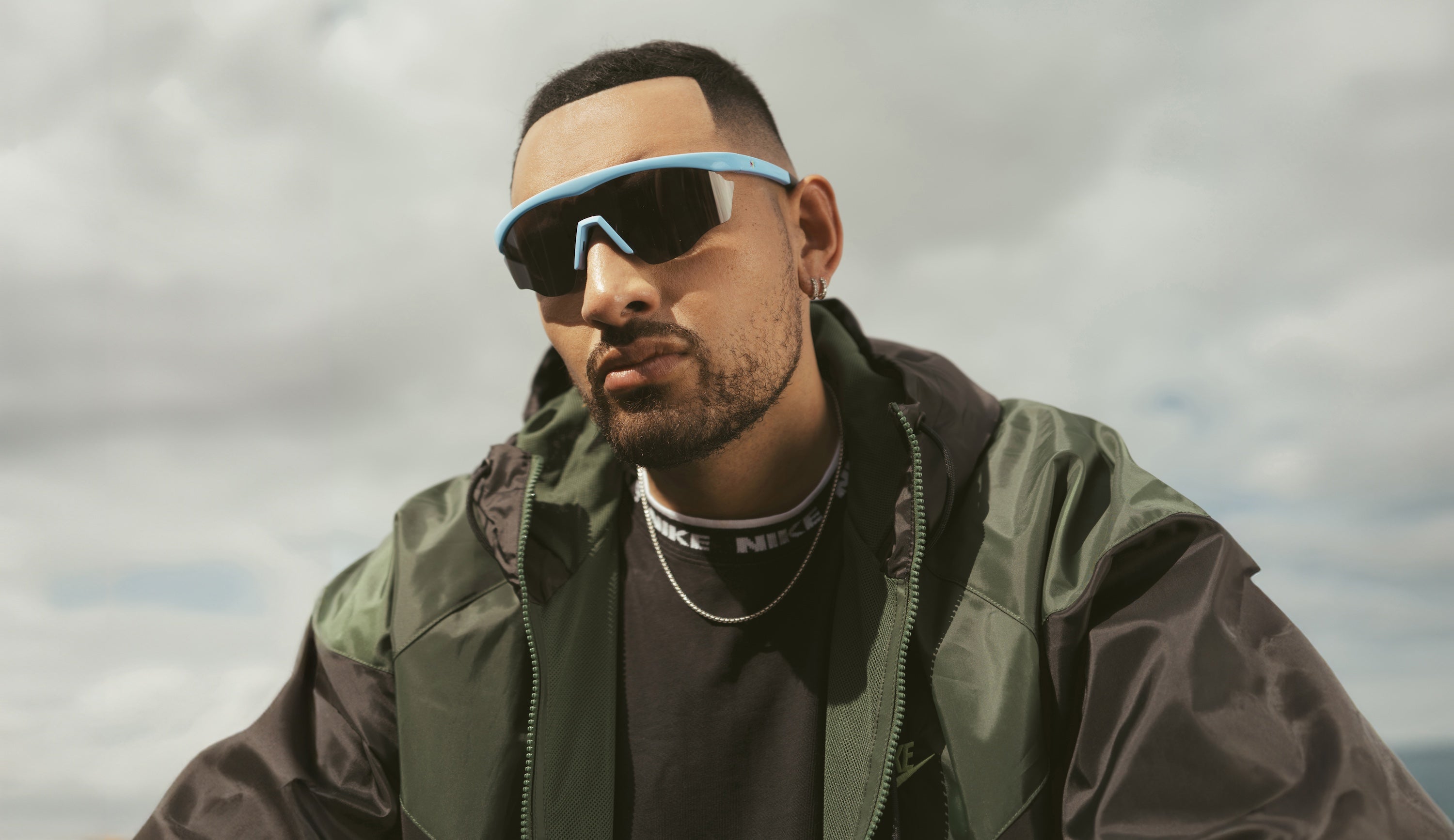 Nick Kyrgios in an olive jacket wearing Nick Kyrgios x illesteva Sports Frame