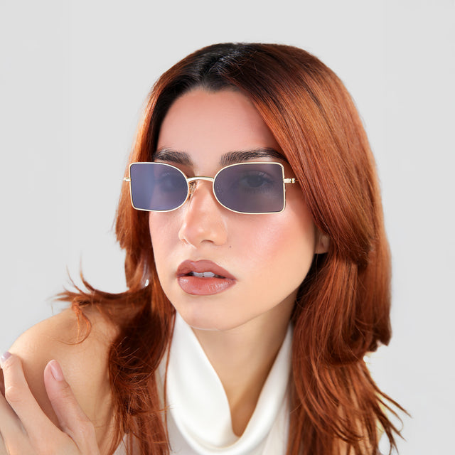 Another angle of woman with red hair looking to her right wearing Nostrand Sunglasses Gold with Grey