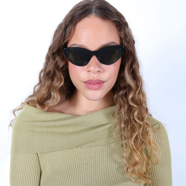 Brunette model with ombré curls wearing Pamela Sunglasses Pine with Olive Flat
