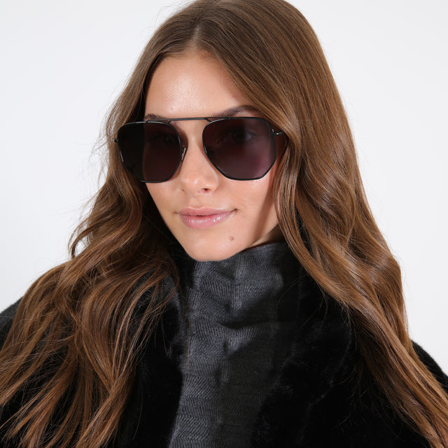 Brunette model in a black fuzzy jacket wearing Patmos 58 Sunglasses Black with Grey Flat