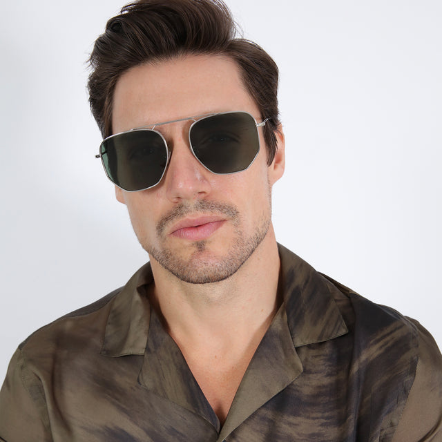 Model with brown hair combed back wearing Patmos 58 Sunglasses Silver with Olive Flat
