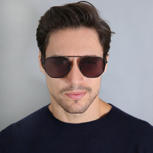 Model with short brown hair wearing Patmos Sunglasses Black with Grey Flat