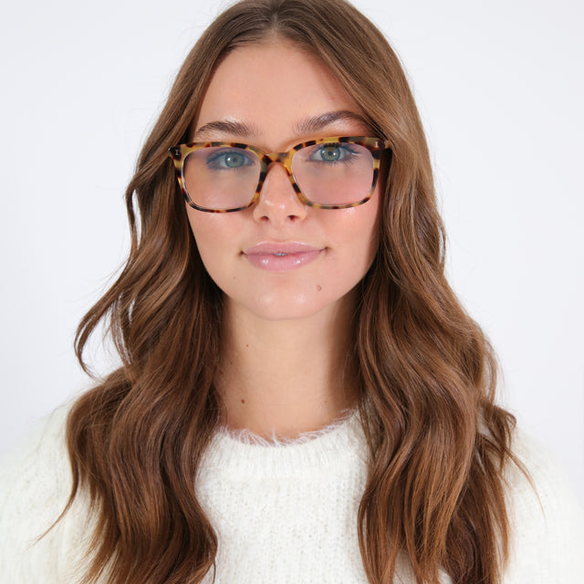 Brunette model with wavy hair wearing Portland Optical Tortoise Optical