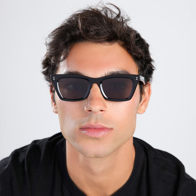 Another angle of man with brown hair in a black shirt wearing Portugal Sunglasses Black with Grey Flat