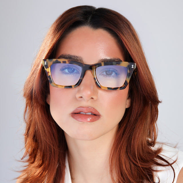 Woman with red hair in a white blouse wearing Portugal Sunglasses Tortoise with Blue Flat Gradient See Through