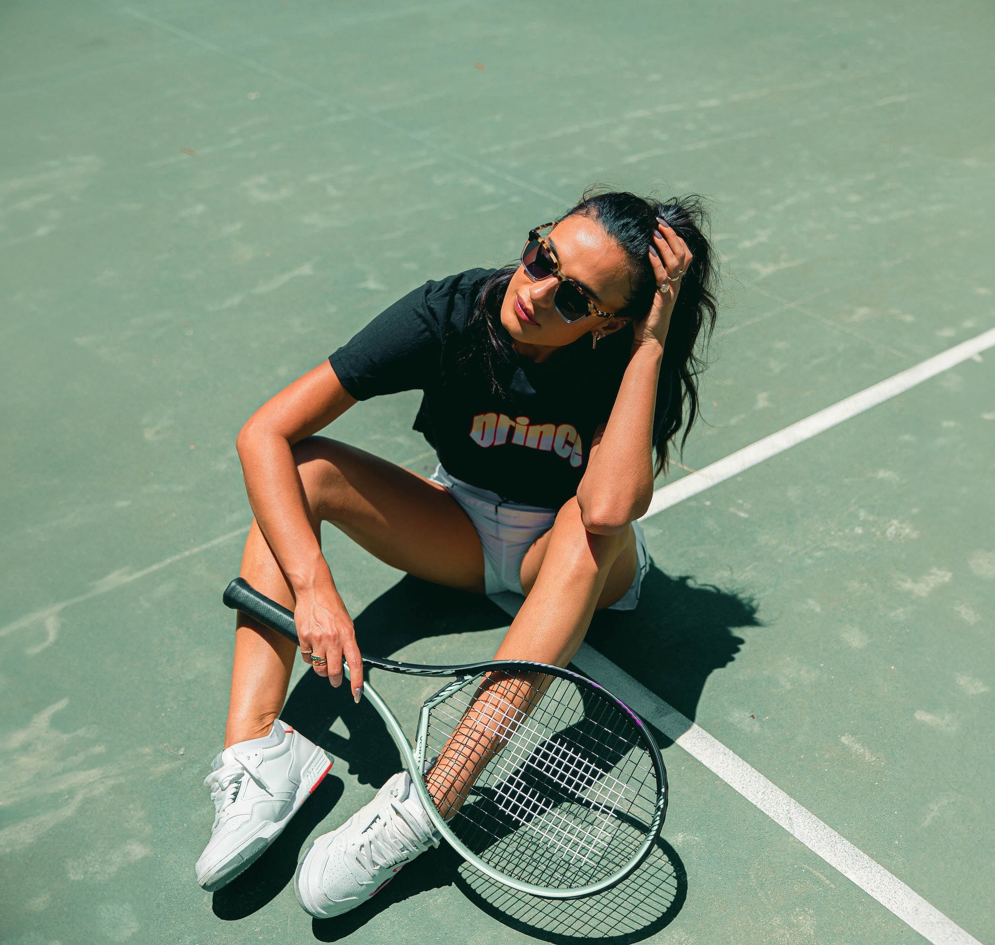 Woman at a tennis court wearing the Prince x illesteva frames
