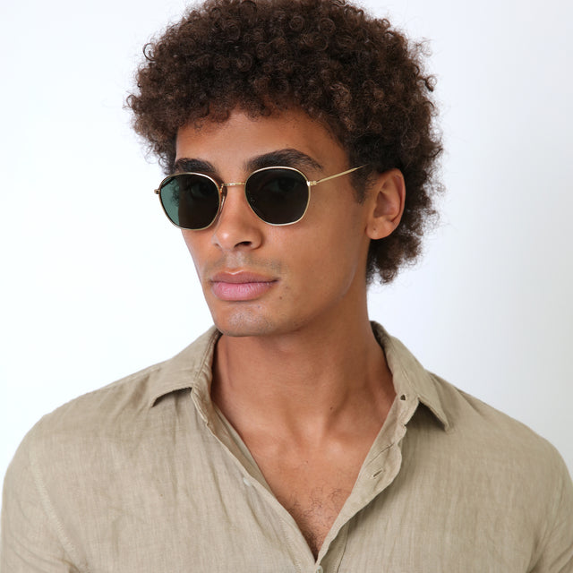 Model with natural curls wearing Prince Sunglasses Gold with Olive Flat