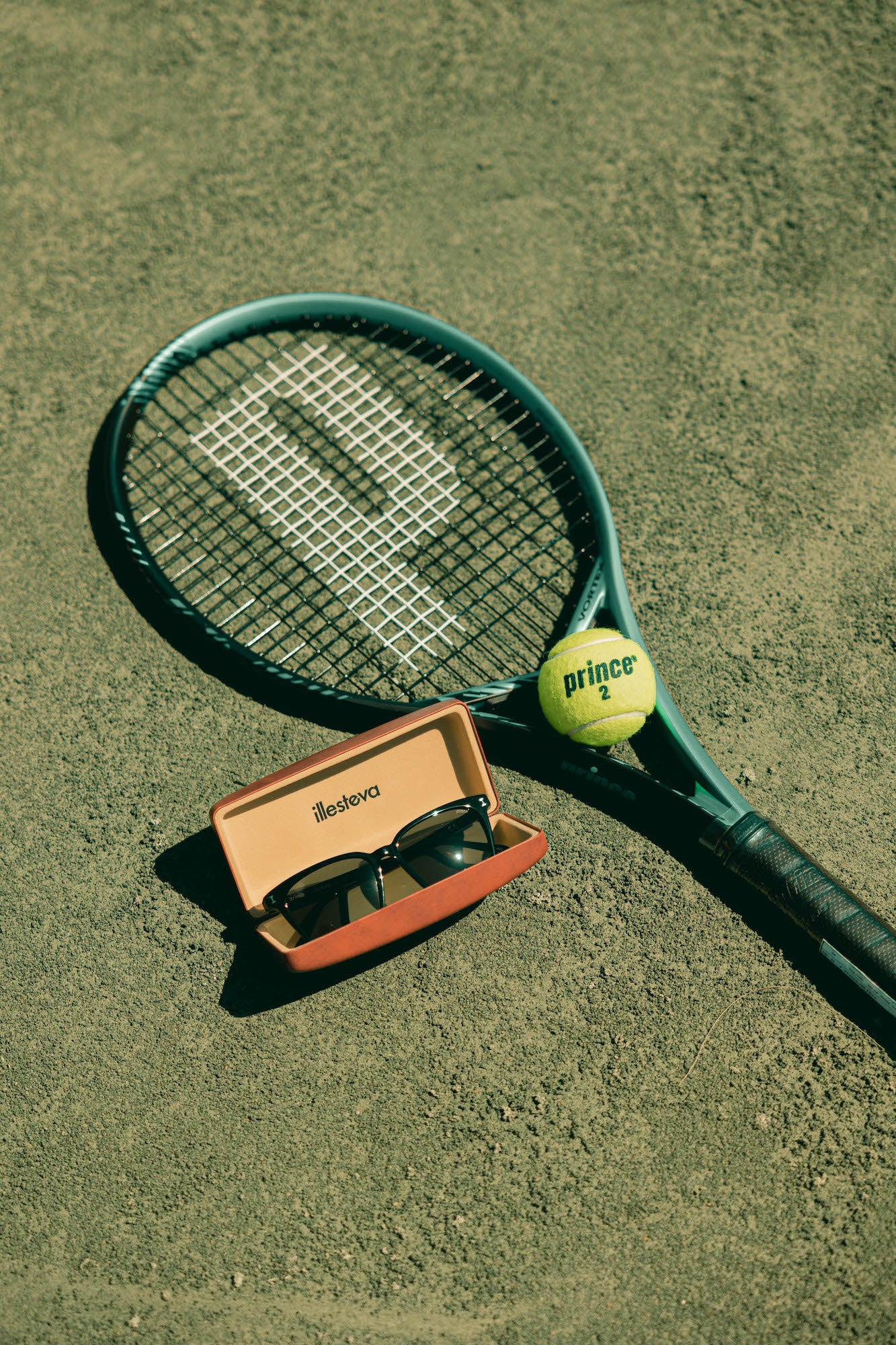 Collaboration frames in black shown next to a Prince tennis racket and tennis ball