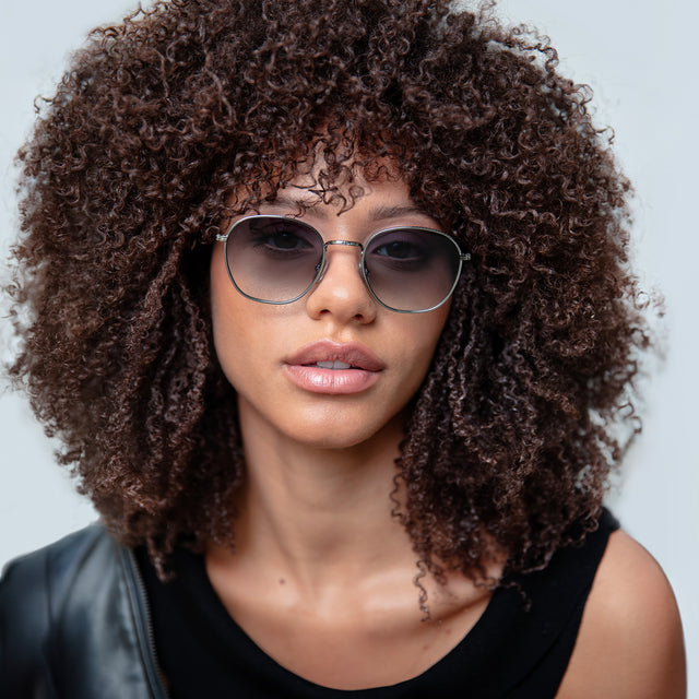 Brunette model with natural small curls wearing Prince Sunglasses Gunmetal with Grey Flat Gradient