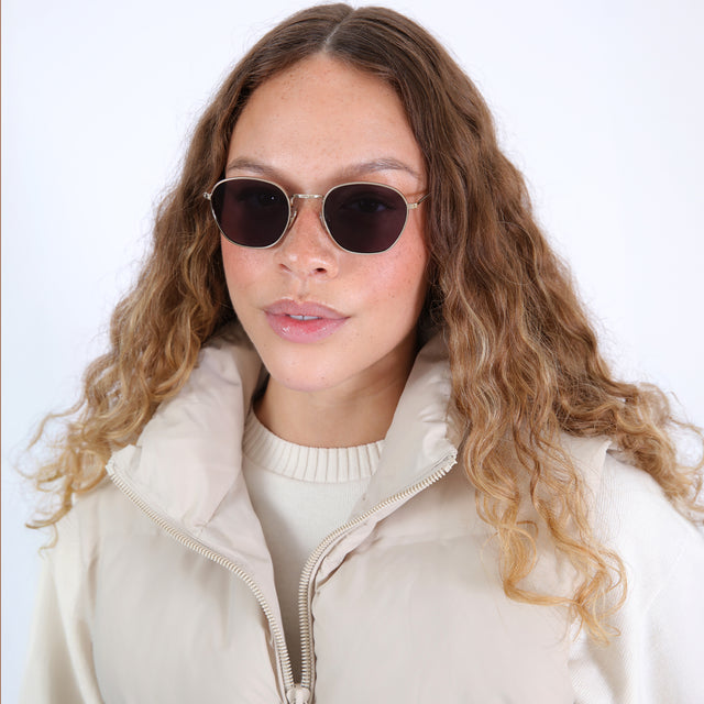 Brunette model with ombré, natural curls wearing Prince Sunglasses Rose Gold with Grey Flat