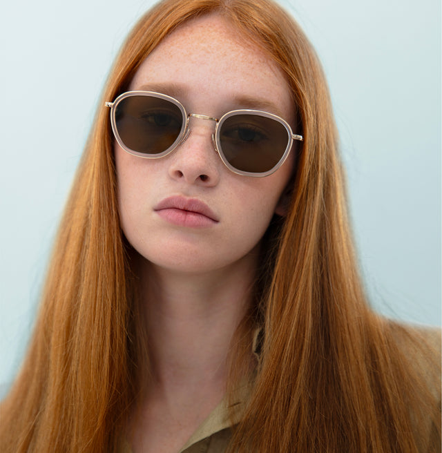 Model with straight, red hair wearing Prince Tate Sunglasses Matte Clear/Gold with Brown Flat