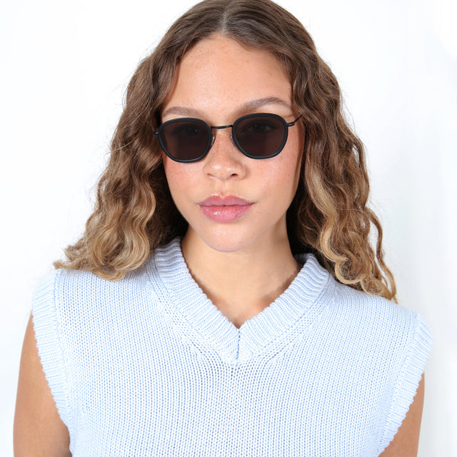 Brunette model with ombré, curled hair wearing Prince Tate Sunglasses Matte Black with Grey Flat
