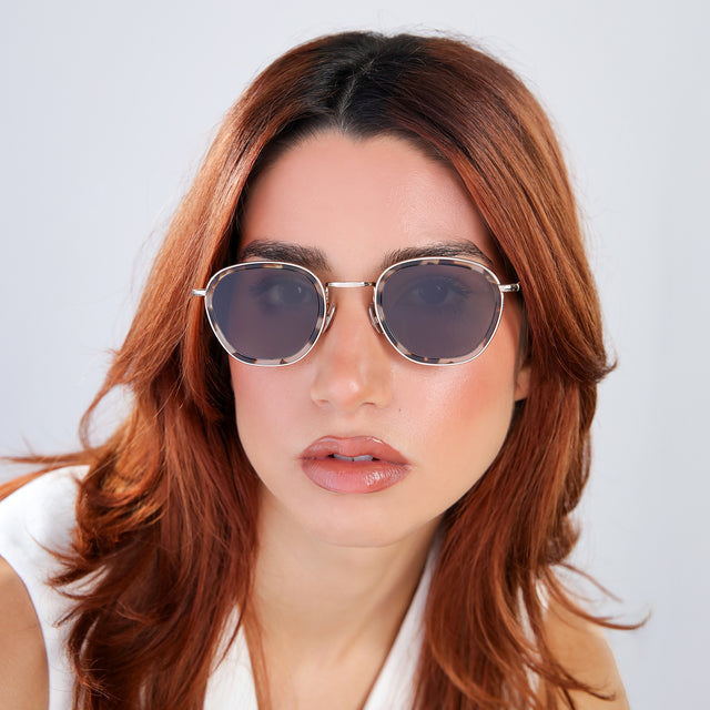 Woman with red hair in a white blouse Prince Tate Sunglasses side view in White Tortoise/Gold / Grey Flat