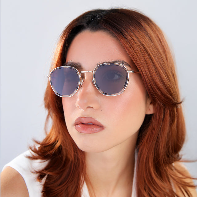 Another angle of woman with red hair in a white blouse Prince Tate Sunglasses side view in White Tortoise/Gold / Grey Flat