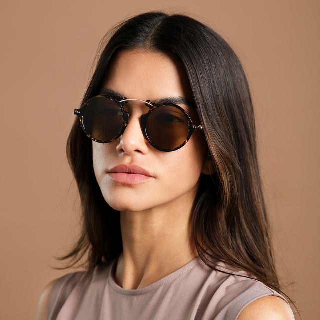 Another angle of brunette model in a clay blouse wearing Roma II Sunglasses Flame/Gold with Brown Flat