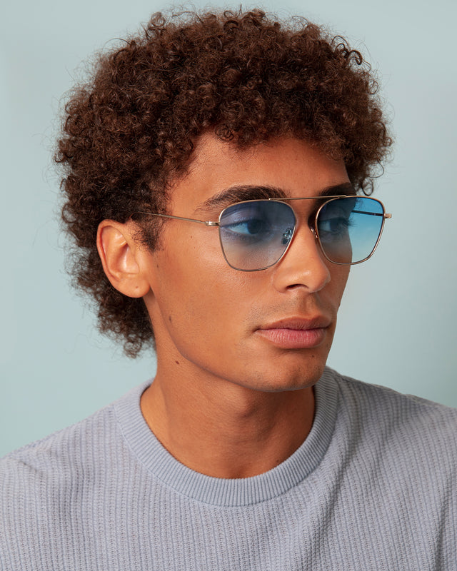 Model with afro-curly hair wearing Samos Sunglasses Gold with Blue Flat Gradient See Through