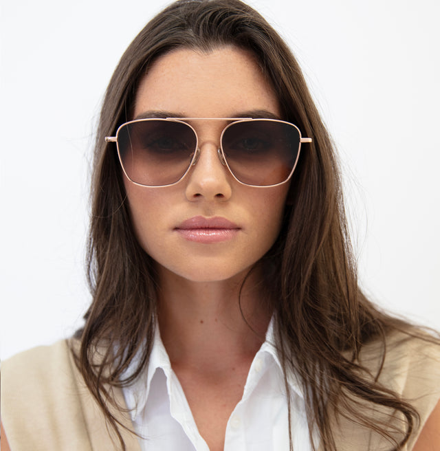 Brunette model with straight hair wearing Samos Sunglasses Rose Gold with Brown Flat Gradient