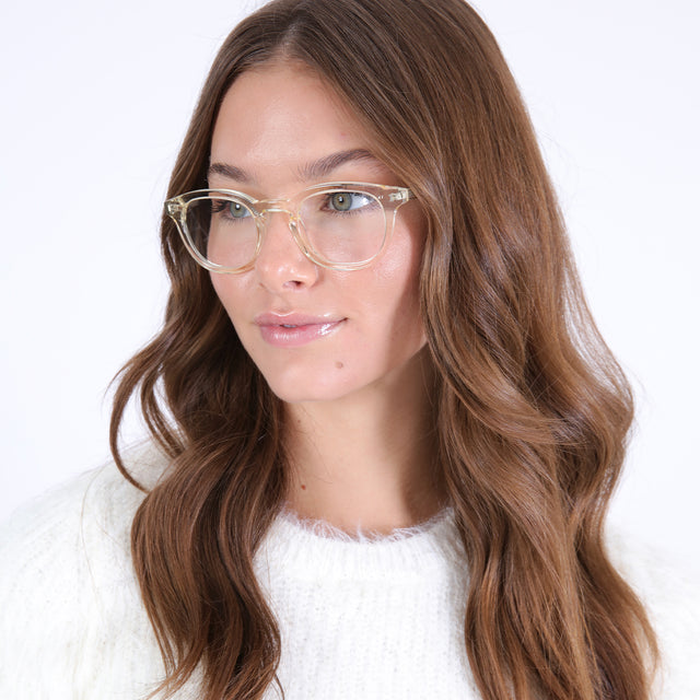 Brunette model with curled hair wearing Slope Optical Champagne Optical
