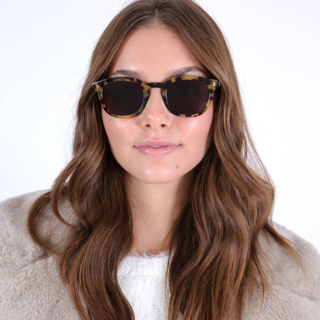 Brunette model with curled hair wearing Slope Sunglasses Tortoise with Grey