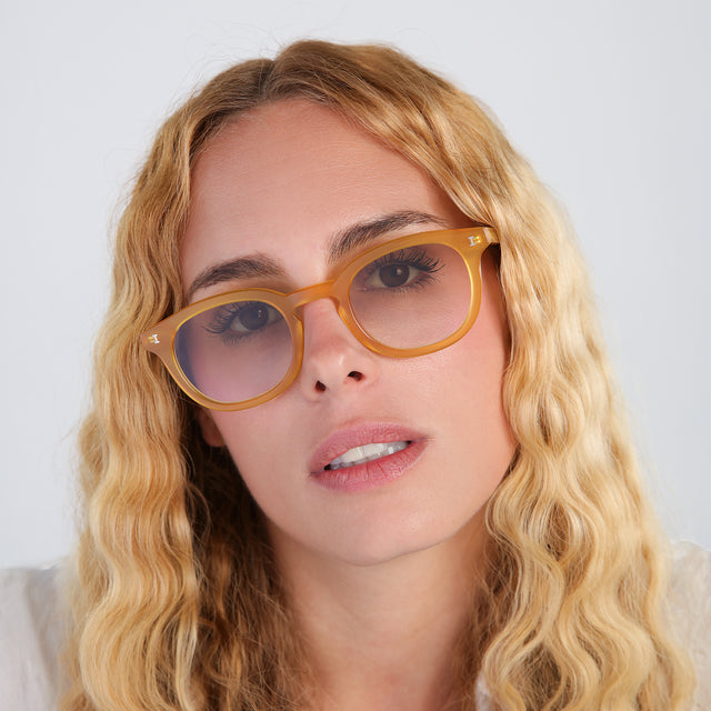 Another angle of woman with blonde, wavy hair wearing Slope Sunglasses Honey Gold with Taupe Flat Gradient