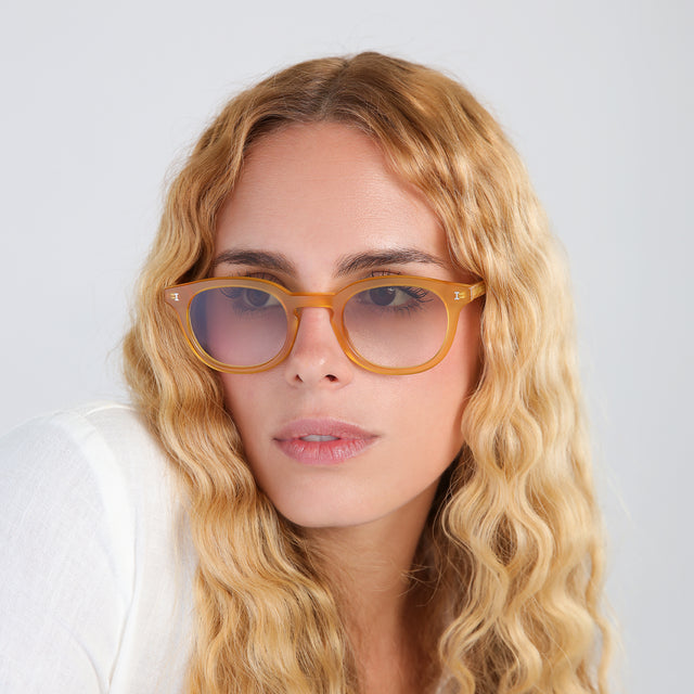 Woman with blonde, wavy hair wearing Slope Sunglasses Honey Gold with Taupe Flat Gradient