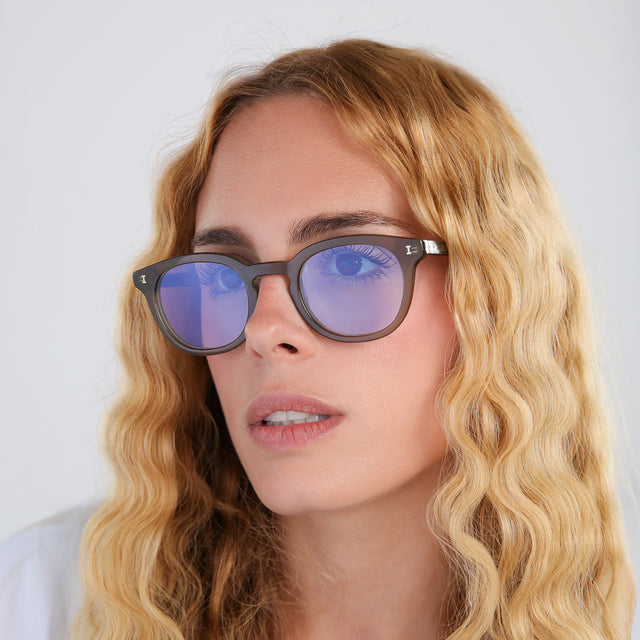 Another angle of woman with blonde, wavy hair wearing Slope Sunglasses Olive with Pale Blue Flat See Through